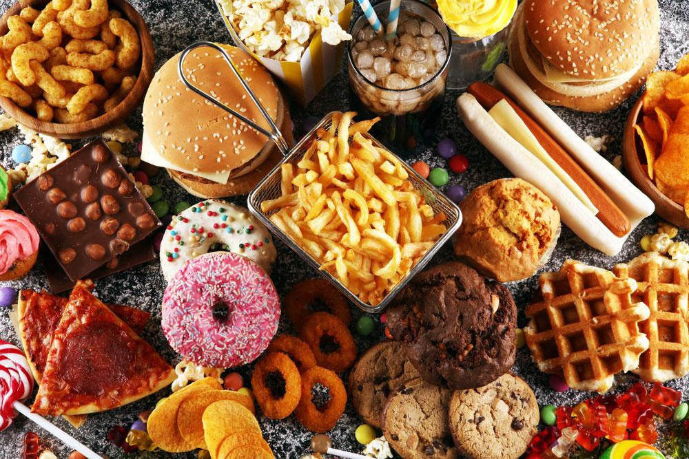 PRÉ-DIABETES: Como reverter essa condição - Um guia baseado em 04 pilares 9 Esta imagem é uma representação colorida e atraente de vários alimentos que devem ser evitados por pessoas com pré-diabetes. A riqueza de cores na imagem torna-a decorativa, enquanto o conteúdo fornece uma mensagem informativa importante.
A imagem mostra uma variedade de doces e balas coloridas, com diferentes formas e tamanhos, representando os açúcares simples que devem ser evitados devido ao rápido aumento dos níveis de glicose que podem causar.
Além disso, a imagem exibe um hambúrguer suculento, cookies recheados, donuts cobertos com glacê e coloridos granulados, e uma salsicha no pão - todos exemplos de alimentos processados ricos em gorduras saturadas e açúcares.
Também são mostrados um cachorro-quente completo com condimentos, salgadinhos em uma tigela, pipoca estourando de um saco, uma fatia de pizza com queijo derretido e um waffle dourado com calda. Estes representam alimentos ricos em carboidratos refinados e sal, que podem contribuir para o aumento dos níveis de glicose no sangue e pressão arterial.
Embora a imagem seja esteticamente agradável devido à sua explosão de cores e variedade de formas, ela serve como um lembrete visual dos alimentos a serem evitados para manter a pré-diabetes sob controle. Por favor, lembre-se de que esta imagem é uma orientação geral e não substitui o aconselhamento médico ou nutricional.