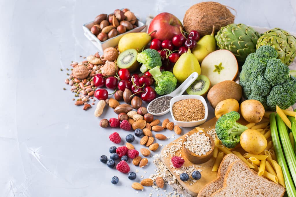 Conceito de dieta balanceada e saudável. Seleção de fontes de fibra ricas em alimentos veganos. Vegetais, frutas, sementes, feijões, ingredientes para cozinhar.