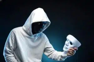 Homem mascarado, com mascara em negro, com máscara em branco na mão, ao estilo Shakespeare, ser ou não ser, representando uma possível psicopatia