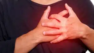 homem segurando o peito ou tórax simulando dor por causa da arritmia cardíaca