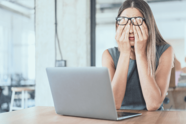 Mulher com fadiga, ela está sentada em frente a um notebook