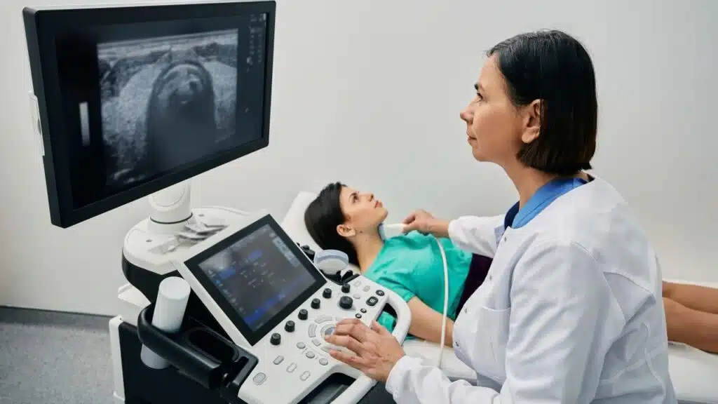 médica realizando um exame de imagem para identificar tireoide em criança