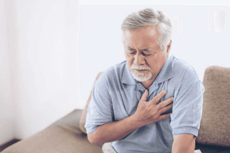 AAS Infantil (Aspirina Prevent): O que você precisa saber 7 um senhor está sentado no sofá com as mãos no peito, principiando um infarto
