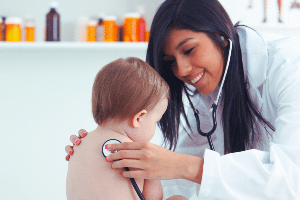 médica ouvindo coração de um bebê com estetoscópio