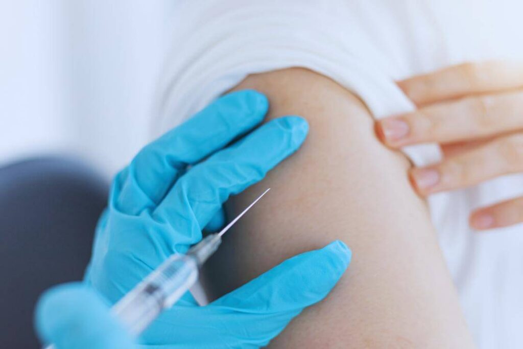 um enfermeiro aplica uma vacina em um paciente