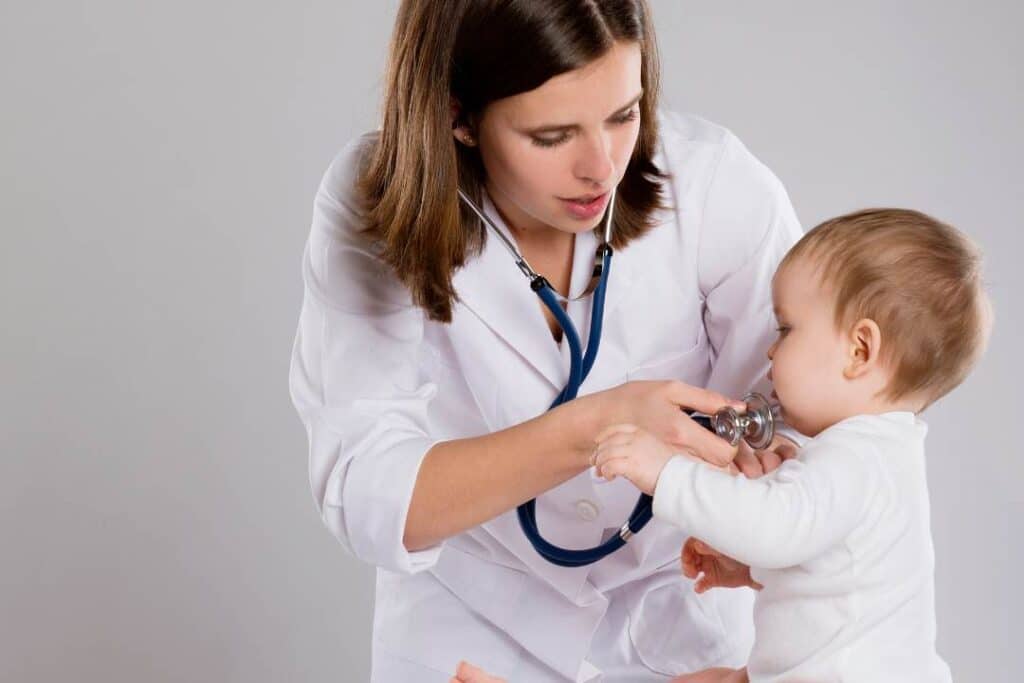 pediatra avaliando um bebe em uma sala de consultório