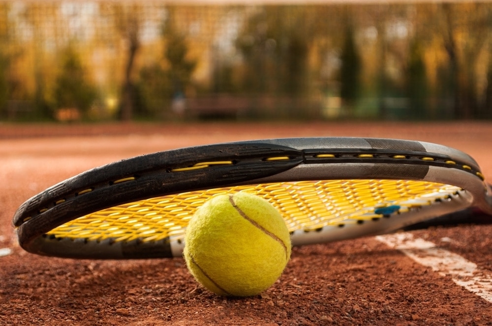 raquete de tênis sobre uma bola de tênis em uma quadra