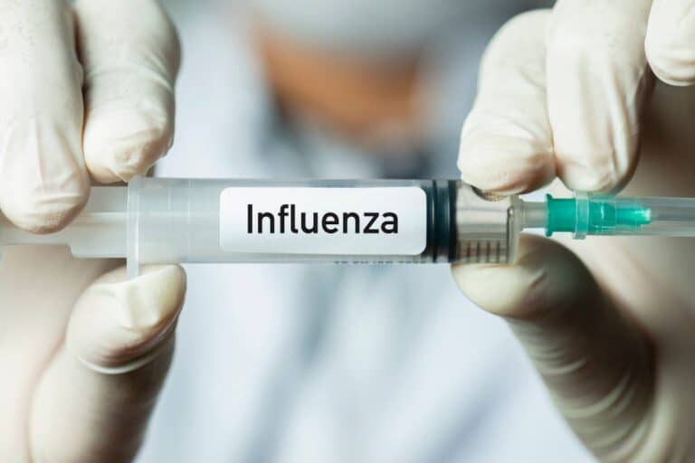 CID J11 — INFLUENZA (GRIPE) DEVIDO A VÍRUS NÃO IDENTIFICADO 7 enfermeiro segurando uma seringa com a inscrição: influenza