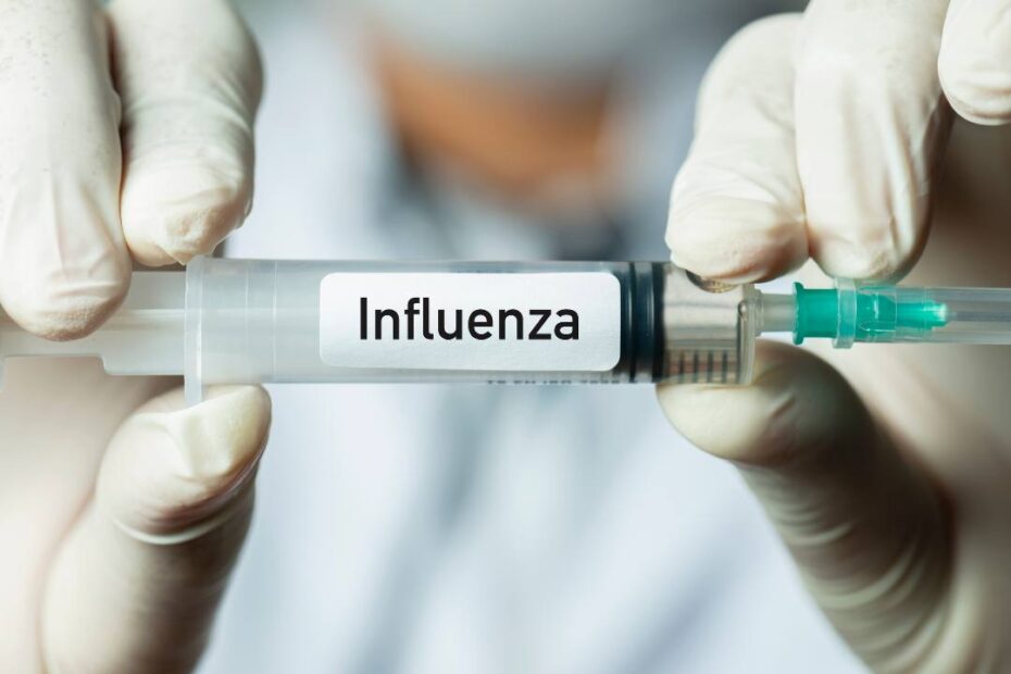 enfermeiro segurando uma seringa com a inscrição: influenza