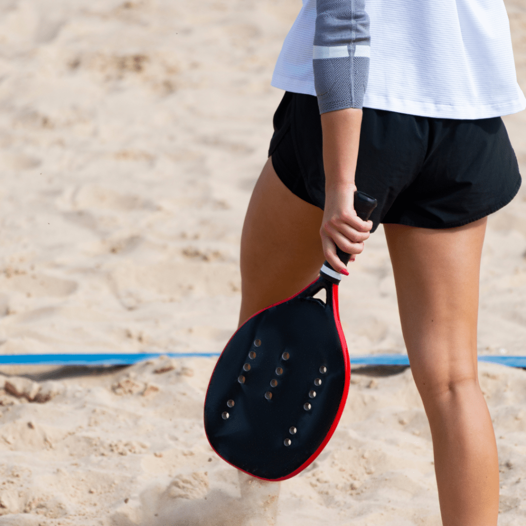 mulher segurando uma raquete de beach tennis