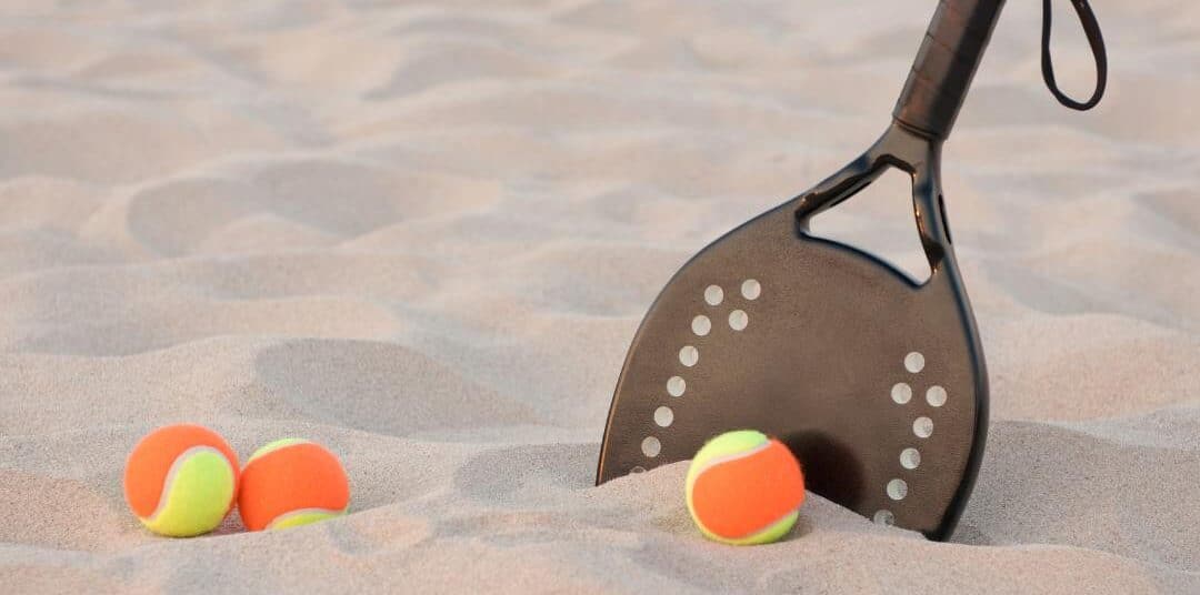 raquete de beach tênis e bolas de beach tennis na areia da praia