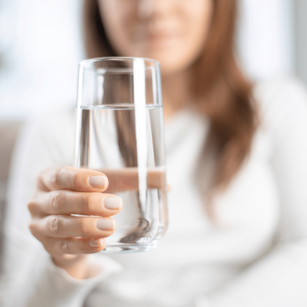 mulher segurando copo de água