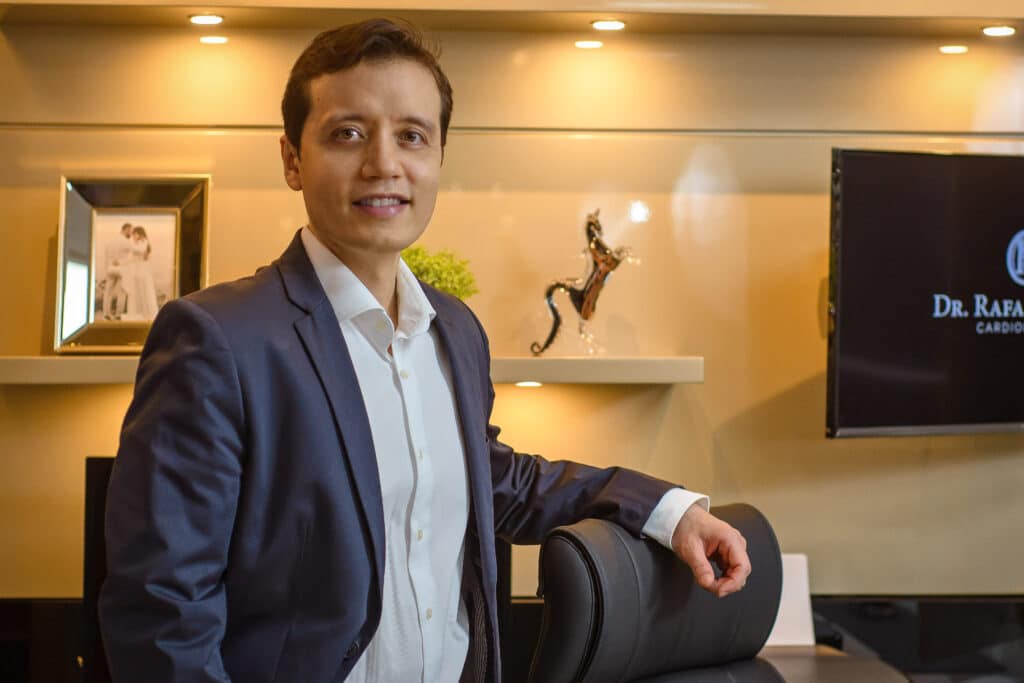 Dr. Rafael Otsuzi em seu consultório, demonstrando profissionalismo e confiança durante atendimento online.